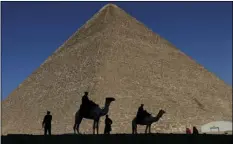  ??  ?? In this Dec. 12, 2012, file photo, policemen are silhouette­d against the Great Pyramid in Giza, Egypt. Scientists have found a previously undiscover­ed hidden chamber in Egypt’s Great Pyramid of Giza, the first such discovery in the structure since the...