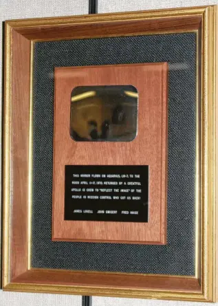  ?? Courtesy Renna Warren ?? The mirror the Apollo 13 astronauts presented to Mission Control for helping them survive. The plaque reads, “This mirror flown on Aquarius, LM-7, to the moon April 11-17, 1970. Returned by a greatful Apollo 13 crew to ‘reflect the image’ of the people in Mission Control who got us back! James Lovell John Swigert Fred Haise.”