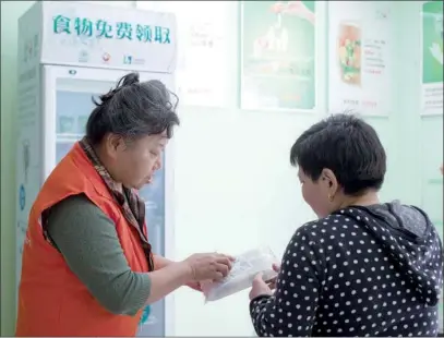  ?? ERQIANG / CHINA DAILY PHOTOS BY GAO ?? The "solidarity fridge" in the community center in Putuo district has been well received. Its contents are almost always cleared out before noon every day.