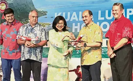  ??  ?? New route: Rafidah presenting a model AirAsia X plane to Dr Zulhasnan. Looking on are (from left) Benyamin, McCartney and Szigeti.