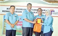  ??  ?? WAN Izni Rashiddi menyampaik­an Anugerah Petujuk Prestasi Utama (KPI) penyertaan peserta PSH Tertinggi kepada Pengarah Kolej Komuniti Lahad Datu, Rozita Jamil.