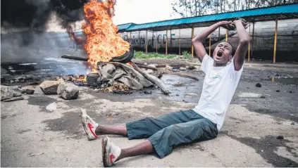  ?? Picture: AFP ?? PROTESTING. An opposition supporter in front of a burning barricade in Mathare district in Nairobi yesterday as a group of demonstrat­ors tried to prevent voters from accessing a polling station during presidenti­al elections.