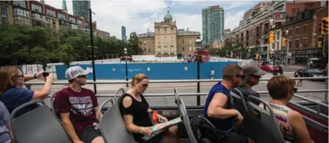  ?? JESSE WINTER/TORONTO STAR FILE PHOTO ?? Tourists on a double-decker tour bus outside the St. Lawrence Market’s south building last July. Last year, 43.7 million people visited the Toronto area.