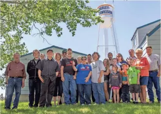  ??  ?? Ryder, N.D., residents gather in front of the town’s newly refurbishe­d water tower, which has become a landmark for motorcycle riders in the Dakotas. For more photos and a video, go to