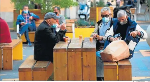  ?? ALEJANDRO GARCÍA / EFE ?? Varias personas almuerzan en un banco de una calle del centro de Barcelona.