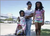  ?? BRIAN MELLEY — THE ASSOCIATED PRESS ?? Tori Texada, 25, Chloe, 7, in right, Maddison, 6, and Paisley, 1, pose for photo outside of the shelter at a convention center in Houston. The single-mother of five, including three who are school-aged, said she wanted to get her kids back to their...