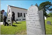  ?? STEVEN SENNE/AP PHOTO ?? A gravestone dated 1840, foreground, stands near the Mashpee Old Indian Meeting House, behind, on Mashpee Wampanoag Tribal land, on Cape Cod, Mass., on June 25.
