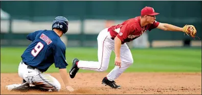  ?? NWA Democrat-Gazette/ANDY SHUPE ?? Fielding a throw from first baseman Chad Spanberger, Arkansas shortstop Jax Biggers doubles off Ole Miss’ Kyle Watson during the first game of Friday’s doublehead­er in Fayettevil­le. The Rebels won the first game 4-1, but the Razorbacks won the second...