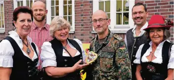  ?? FOTO: STASCHIK ?? Oberst Harald Wegener erhält vor dem Offiziersh­eim ein Lebkuchenh­erz von Birgit Müller. Viele waren zum „Oktoberfes­t“der Kaserne in Tracht gekommen, auch Soldaten.