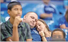  ?? AP - Phelan M. Ebenhack, file ?? Two Tampa Bay Rays fans sleep in the stands during the 16th inning of a game against the Orioles in 2013. The aim of the new extra-innings rule is to limit such long games.