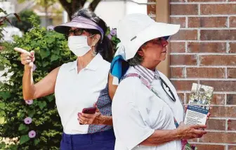  ?? MichaelWyk­e / Contributo­r ?? Texas Latino Conservati­ves volunteers Alicia Stuart, left, and Grace Aguilar ring doorbells and hang political brochures on doors as they block-walk in Cypress on Saturday.