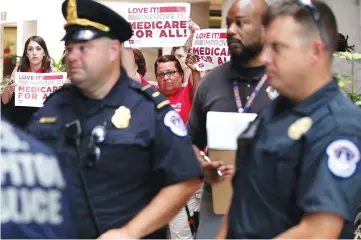  ??  ?? Activists hold signs in a protest against the Republican health care repeal-and-replace legislatio­n at the Hart Senate Office Building on Capitol Hill in Washington, DC.