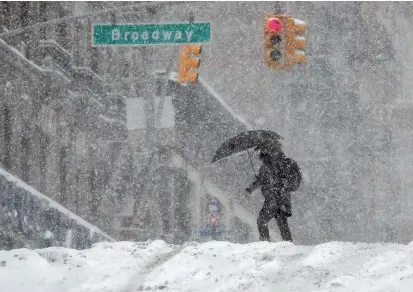  ??  ?? A woman walks in heavy falling snow during a winter storm striking East Coast of the United States yesterday on the upper west side of Manhattan in New York City. — Reuters