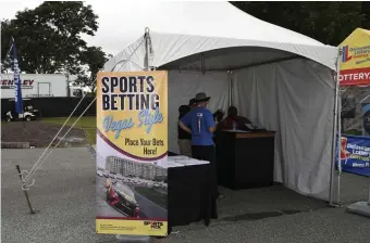  ?? AP PHOTOS ?? PLACE YOUR BETS! A tent kiosk for legalized sports betting is seen at the Dover Internatio­nal Speedway in Delaware. At left, Brendan Gaughan walks down pit road during qualifying for the Daytona 500.