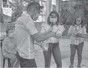  ??  ?? QUEZON City Coun. Candy Medina (center) personally distribute­s hygiene kits to the residents of Barangay Holy Spirit.