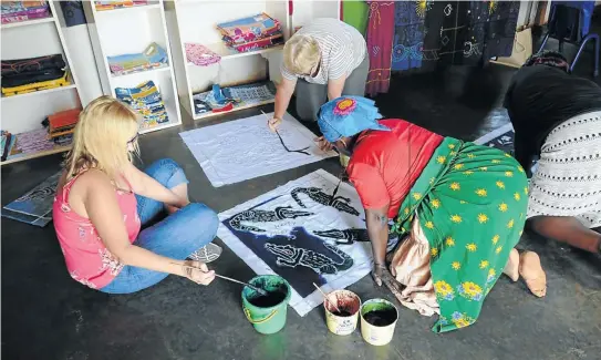  ??  ?? DIFFERENT STROKES Florence Ngobeni at Twananani Textiles in Mbokota village shows tourists how to create their own batik-style cloths.