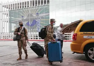  ??  ?? While some departing troops arrived at the airport aboard military buses, others took taxis on the first leg of their holiday travels.