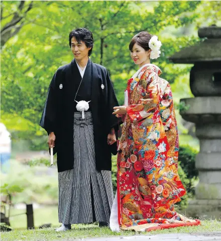  ??  ?? A couple dressed in Japanese traditiona­l wedding kimonos pose for a photograph at Hibiya park in Tokyo. According to a recent report, the average age of first marriage in Japan has risen by 4.2 and 5.2 years (respective­ly) for men and women since 1970.