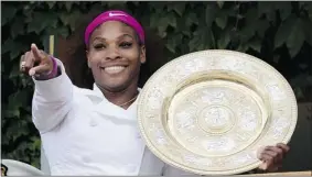 ?? Reuters ?? Serena Williams holds her trophy as she stands on the clubhouse balcony after defeating
Agnieszka Radwanska in their women’s final tennis match at Wimbledon on Saturday.
