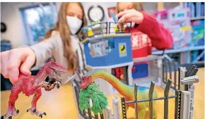  ?? FOTO: DANIEL KARMANN/DPA ?? Nina (l.) und Lena spielen mit Dinosaurie­rn.