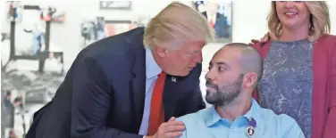  ?? ASSOCIATED PRESS ?? President Donald Trump talks with U.S. Army Sgt. 1st Class Alvaro Barrientos after awarding him a Purple Heart on Saturday at Walter Reed National Military Medical Center in Bethesda, Md.