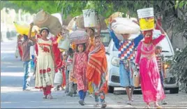  ?? PARDEEP PANDIT /HT ?? ■ Migrants from Uttar Pradesh and Bihar carrying household items on their way to the railway station in Jalandhar on Monday.