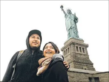  ?? CAROLYN COLE Los Angeles Times ?? DEREK AND BRENDA ESCOBEDO of Anaheim were able to visit the Statue of Liberty after New York state agreed to pay to keep it open. Visitors to other national parks and monuments weren’t so lucky.