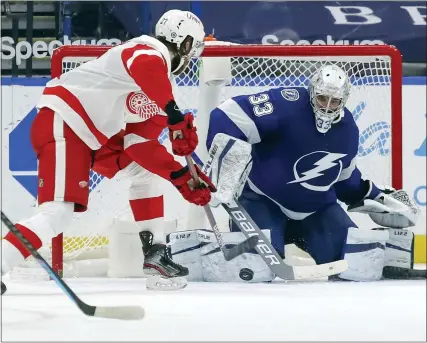  ?? MIKE CARLSON PHOTOS — THE ASSOCIATED PRESS ?? Detroit Red Wings’ Michael Rasmussen, left, scores past Tampa Bay Lightning goaltender Christophe­r Gibson during Sunday’s 5-1victory in Tampa, Fla. It was the Red Wings first road win against the Lightning since Feb. 17, 2011, a losing streak of 17games overall.