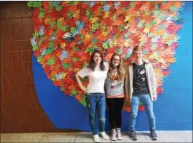  ?? COURTESY OF STEPHANIE STAMM ?? Paige Wenhold, Randi DeWalt, and Jason Eidle in front of the Positivity Tree.