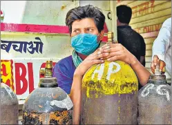  ?? AFP ?? A man waits to refill oxygen cylinders for Covid-19 patients at a centre in New Delhi on Friday.