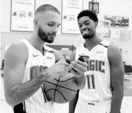  ?? JOHN RAOUX/ASSOCIATED PRESS ?? Magic swingman Even Fournier, left, checks out the cellphone photos taken by teammate Amile Jefferson during the team’s media day event Monday at Amway Center.