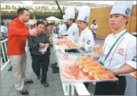  ?? GAO ERQIANG / CHINA DAILY ?? Visitors are invited to taste Norwegian salmon at the 2010 World Expo in Shanghai.