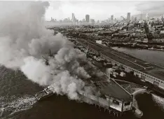  ?? Paul Kuroda /
San Francisco Chronicle ?? Firefighte­rs spray water on the Pier 45 fire, which began early Saturday in San Francisco. The fire threatened the SS Jeremiah O’Brien, a liberty ship that stormed Normandy on D-Day in 1944. The ship docks by Pier 45 and is among numerous tourist attraction­s on the wharf, a maritime hub for cruises around San Francisco Bay as well as fishing boats hauling in the catch of the day.