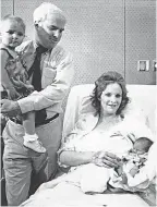  ?? DAVID PETKIEWICZ/ARIZONA REPUBLIC ?? Then-Rep. John McCain, R-Ariz., holds his daughter Meghan, and wife Cindy holds the couple’s new baby, John Sidney McCain IV, at Good Samaritan Medical Center in Phoenix in May 1986.