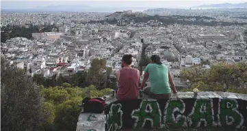  ??  ?? Young men sit at a hill overlookin­g the city of Athens. As the fiscal crunch ate away a quarter of Greece’s economy, some 300,000 Greeks – among them the best educated – emigrated, and unemployme­nt soared to highs of nearly 28 per cent in 2013. — AFP photo