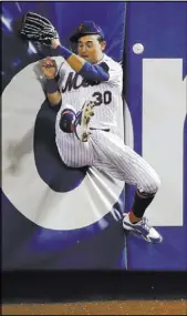  ?? Julie Jacobson The Associated Press ?? Mets center fielder Michael Conforto slams into the wall in pursuit of a ball hit for a double by Jason Heyward in the seventh inning of the Cubs’ 7-1, 14-inning win Saturday at Citi Field.