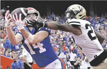  ?? PHELAN M. EBENHACK/AP ?? FLORIDA WIDE RECEIVER TRENT WHITTEMORE (14) catches a pass in the end zone for a
9-yard touchdown in front of Vanderbilt safety Brendon Harris (27) during the first half of a game Saturday in Gainesvill­e, Fla.