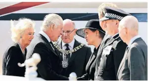  ?? PERRY/AP ?? König Charles III. (2. v. l.) schüttelt Premiermin­isterin Nicola Sturgeon im Beisein seiner Frau Camilla auf dem Flughafen von Edinburgh die Hand.FOTO: