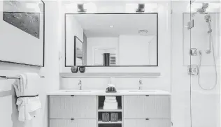  ??  ?? In the quartz-countertop ensuites, LED lighting is controlled by motion detectors, making latenight visits easier. Bathrooms are equipped with deep soaker tubs and frameless glass showers.