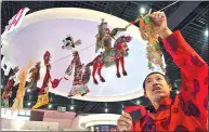  ?? LI SHENGLI / FOR CHINA DAILY ?? A craftsman from Huanxian county, Gansu province, shows puppets at a cultural expo.
