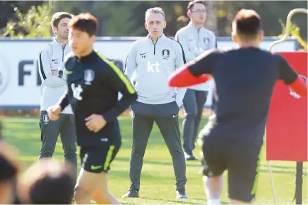  ?? Yonhap ?? Paulo Bento, center, head coach of the South Korean men’s national football team, watches his players during practice at the National Football Center in Paju, Gyeonggi Province, Tuesday.