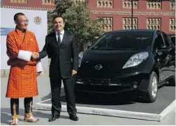  ?? NISSAN MOTOR CO./ THE ASSOCIATED PRESS ?? Bhutanese Prime Minister Tshering Tobgay, left, and Nissan ’ s Carlos Ghosn pose with the new electric Leaf in Thimphu, Bhutan . Under a deal announced Friday, Nissan will help Bhutan achieve its goal of becoming a zero- emissions nation.