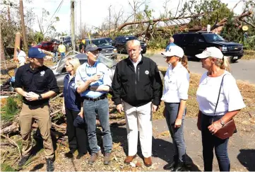  ?? — Reuters photo ?? Trump and Melania talk with Fema director Brock Long, Nielsen, Scott and Lynn Haven Mayor Margo Anderson as they tour areas ravaged by Hurricane Michael in Lynn Haven, Florida.