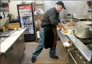  ?? Raleigh News & Observer/TRAVIS LONG ?? Robert Cardoso, shown here making Cuban sandwiches at the Havana Grill in Cary, N.C., is helping other Hispanic business owners now that his own restaurant has become successful.