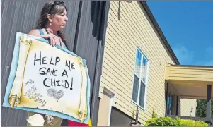  ?? RYAN ROSS/THE GUARDIAN ?? Ivy Inkpen holds a protest sign outside the Montague Curling Club Thursday morning where Prime Minister Justin Trudeau held a meet-and-greet with a few hundred people.