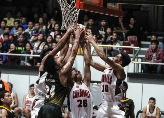  ?? Photo by Jean Nicole Cortes ?? HUSSLE. University of Baguio Cardinals and Baguio College of Technology Atoms battle in mid-air for ball possession during the Baguio Benguet Educationa­l Athletic League (BBEAL) men’s basketball tournament at the UB gym.