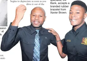  ??  ?? Below: Michael Collins, sales developmen­t and training specialist, JN Bank, accepts a branded rubber bracelet from Xavier Brown.