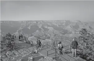  ?? ADRIANA ZEHBRAUSKA­S/NEW YORK TIMES ?? Visitors walk along the south rim July 8 at Grand Canyon National Park in Arizona. National parks — sometimes many miles from equipped hospitals — are grappling with how to safely stay open.