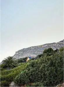  ?? ?? With its simple, ‘tent-like’ shape, the cabin nestles unobtrusiv­ely in its surroundin­gs against a hillside in Muizenberg, Cape Town.