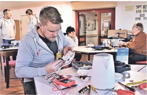  ?? FOTO: DOMINIK SCHNEIDER ?? Christian Eck schraubt am Wasserkoch­er. Die defekte Heitzspira­le übersteigt allerdings die Möglichkei­ten des Hobby-Tüftlers.